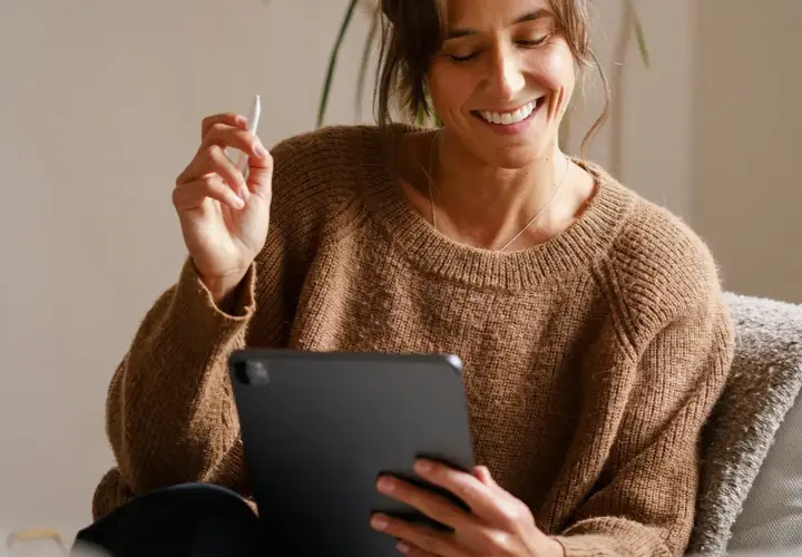 Uśmiechnięta kobieta z rysikiem w dłoni przegląda coś na tablecie. Jaki tablet, taki komfort pracy!