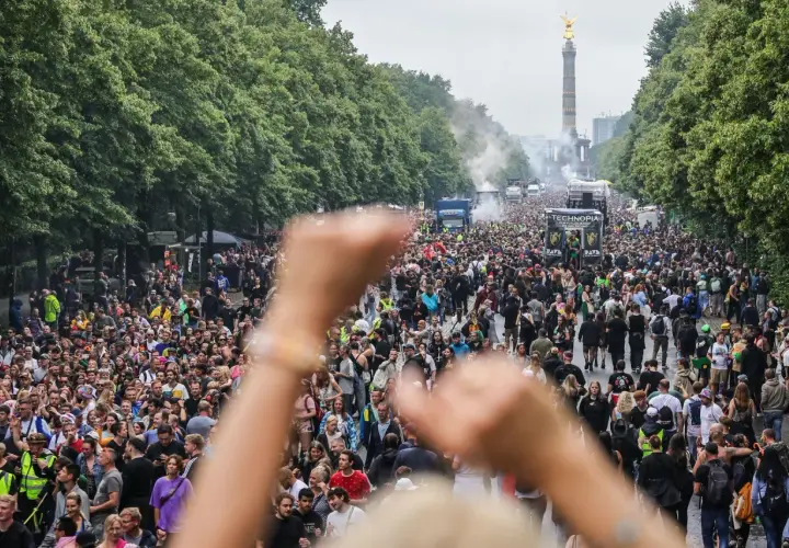 Tłum ludzi na ulicy, ciężarówki z muzyką i Złota Zwycięzca w tle. To jest **love parade** w pełnej krasie!