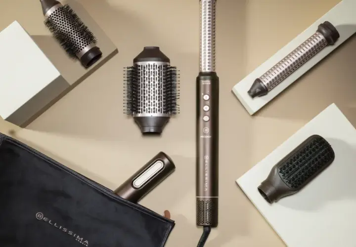 Herramientas para un blow out hair perfecto: cepillos redondos, un rizador y un cepillo plano, junto a un estuche.
