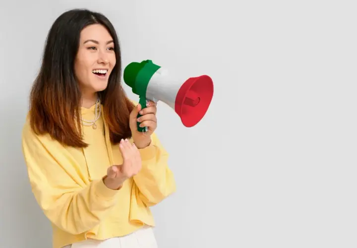 Ragazza con megafono tricolore italiano, che annuncia "mercoledì in inglese pronuncia" con entusiasmo.