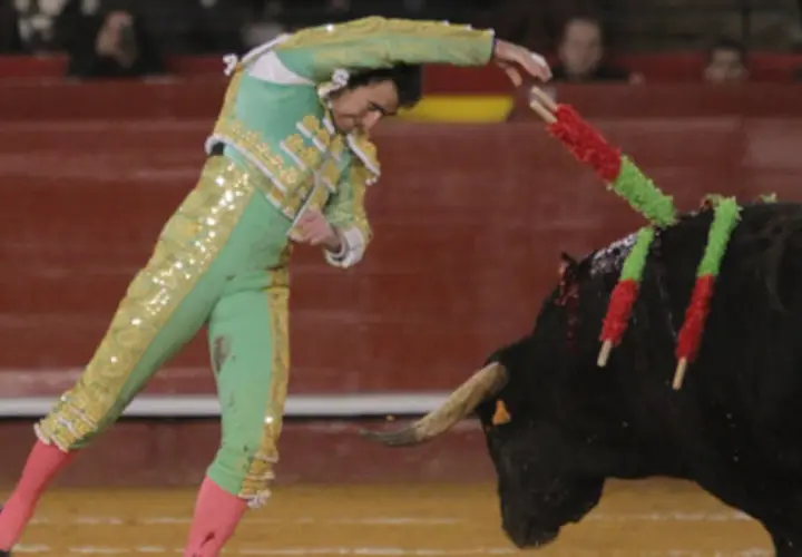El torero El Fandi clava las banderillas en el lomo del toro, un momento de gran tensión en la plaza.