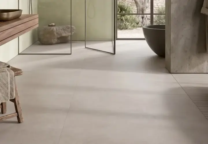 Bagno moderno con gres porcellanato effetto cemento. Pro: stile minimal, facile da pulire. Contro: può risultare freddo al tatto.