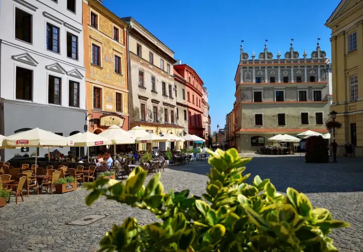 Słoneczny dzień na lublin stare miasto. Kolorowe kamienice, kawiarniane ogródki i brukowany plac tworzą urokliwą atmosferę.