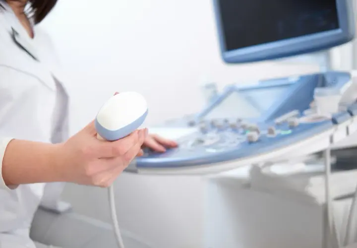 Lekarz trzyma sondę aparatu USG, przygotowując się do badania echo serca. Prawidłowe parametry echo serca są kluczowe dla diagnozy.