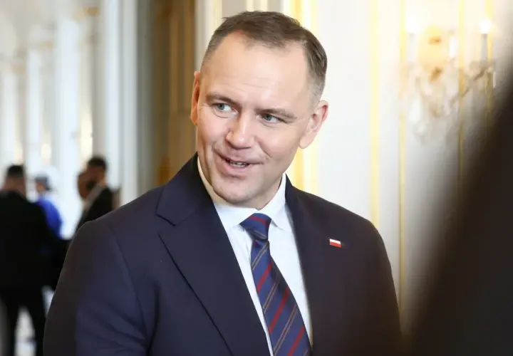 Prezydent Andrzej Duda w garniturze, z flagą Polski na klapie. Zastanawiasz się, ile zarabia prezydent Duda?