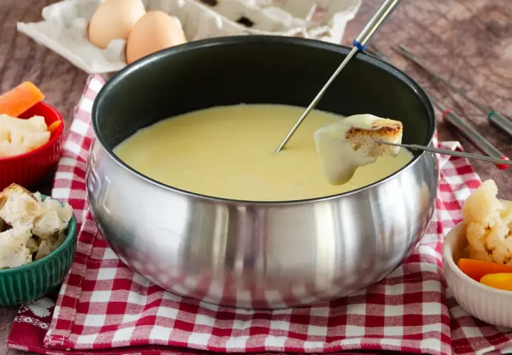 Una deliziosa fonduta Valle d'Aosta, con pane croccante e verdure fresche, pronta per essere gustata.
