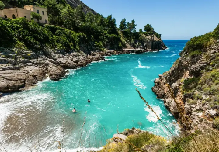 Baignade dans les eaux turquoise d'une crique isolée, un rêve de vacances sur la côte amalfitaine.