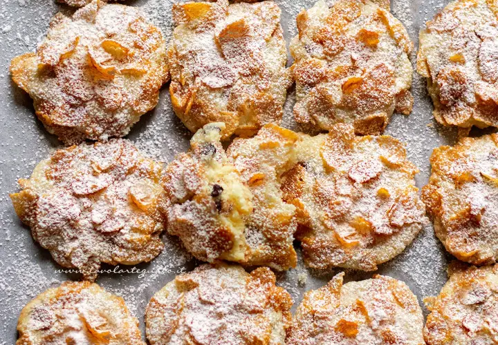 Biscotti croccanti, simili a rose del deserto, ricoperti di zucchero a velo e fiocchi di mais.