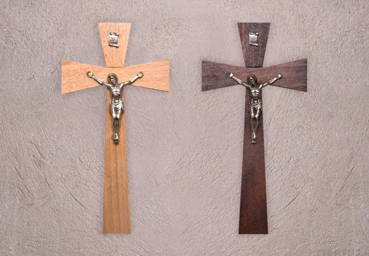 Dwa drewniane krzyże z figurkami Jezusa. Jeden jasny, drugi ciemny. Symbol wiary, jak tatuaż krzyż na palcu znaczenie.