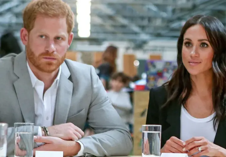 Meghan i Harry siedzą przy stole, rozmawiając.