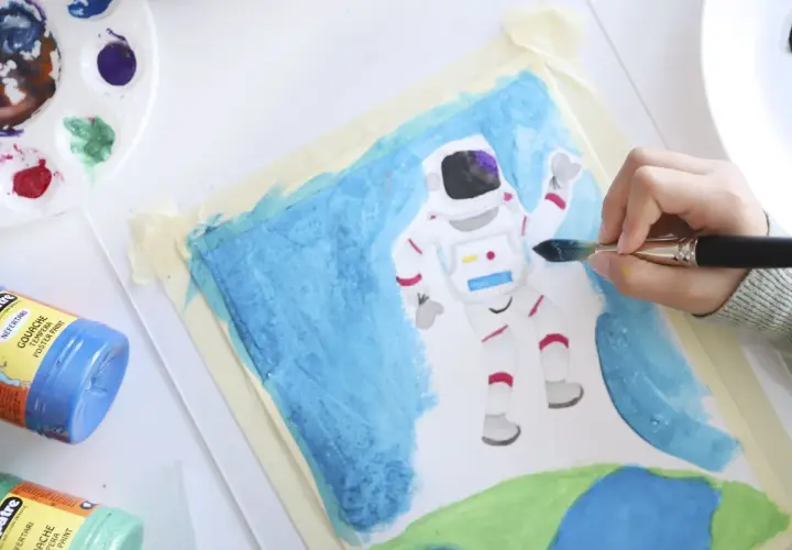Niño pintando un astronauta en el espacio. Un proyecto de arte en infantil que fomenta la creatividad y la imaginación.
