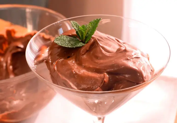 Deliciosa crema de cacao pralin, servida en copa de cóctel y decorada con menta fresca.