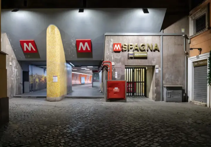 Ingresso della stazione metro Spagna a Roma, con insegna luminosa e pavimentazione in sampietrini.