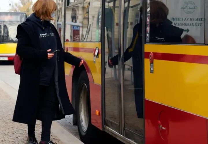 Kobieta z telefonem w ręku zbliża się do autobusu, by skasować bilet elektroniczny.