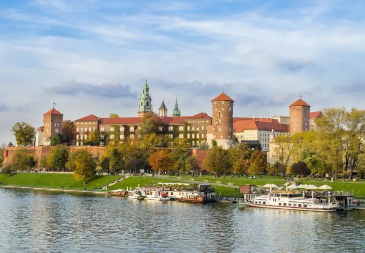 Zabytkowe miasto nad Wisłą, Wawel w jesiennej odsłonie. Statki wycieczkowe cumują przy brzegu.