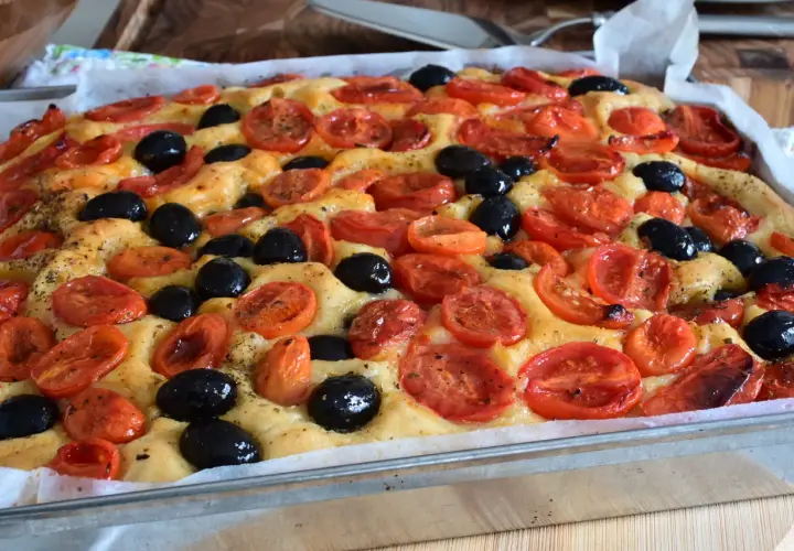 Focaccia con pomodorini e olive nere, un'esplosione di sapori che ricorda la semplicità di un pasto come quello di Rossella, pane e cioccolato.