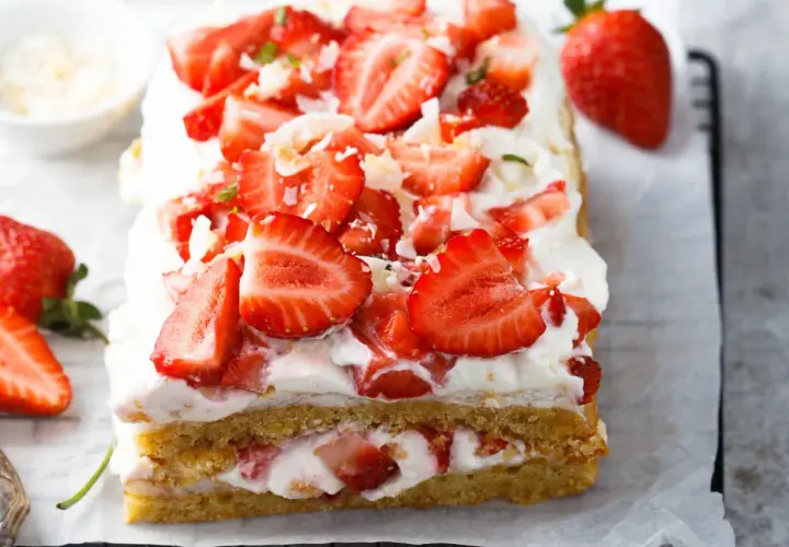 Ein saftiger Erdbeerkuchen, perfekt für jedes Erdbeerkuchen Rezept. Mit frischen Erdbeeren und viel Sahne belegt.