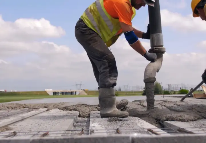 Robotnicy wylewają beton na strop Teriva. Widać pompę do betonu i zbrojenie.