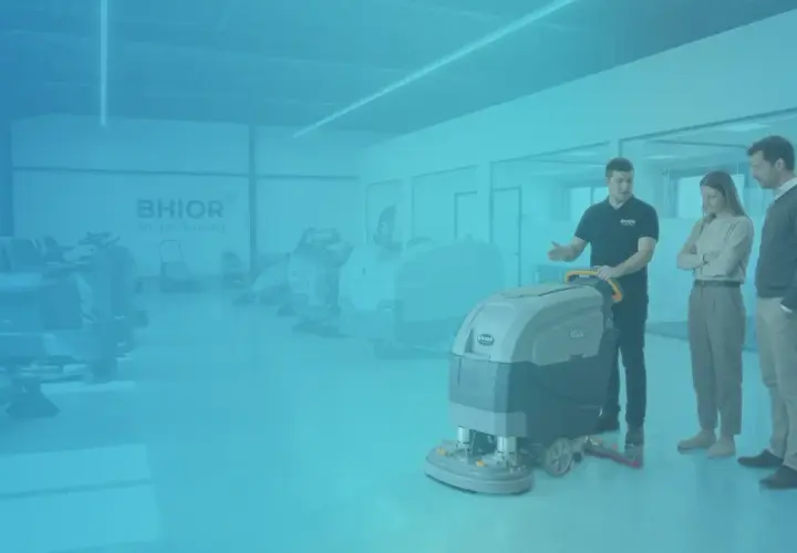 Un vendedor muestra equipos de limpieza industrial a dos clientes.