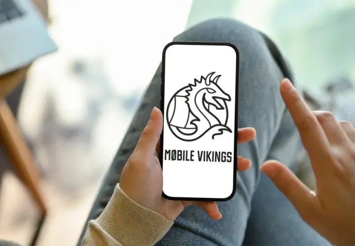 Ręka trzyma smartfon z logo Mobile Vikings. To sieć komórkowa dla tych, którzy cenią wolność i niezależność.