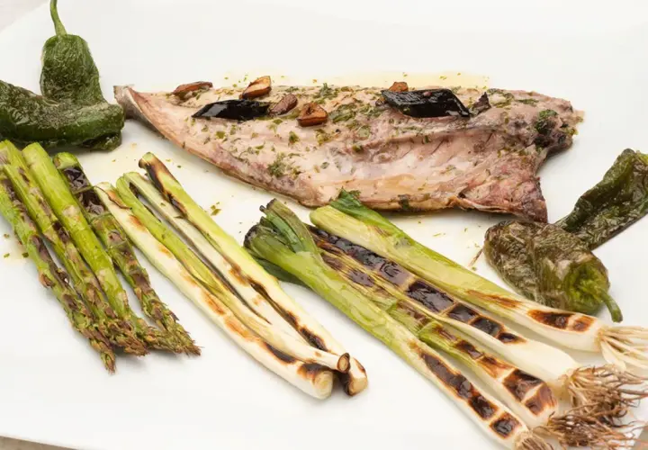 Pescado chicharro a la plancha con espárragos, pimientos de Padrón y cebolletas asadas.