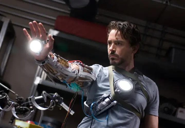 Tony Stark, w którego wciela się Robert Downey Jr. (iron man obsada), testuje nową rękawicę z repulsorami.