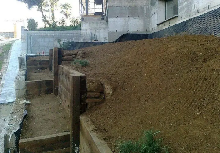 Costruzione di terrazzamenti con travi di legno per livellare pavimento in pendenza.