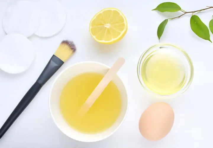 Ingredientes para una mascarilla casera para el pelo: huevo, limón, aceite y aplicador.