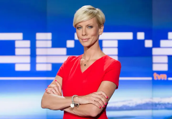 Małgorzata Łaszcz, dziennikarka, w czerwonej sukience, z krótkimi blond włosami, na tle studia TVN.
