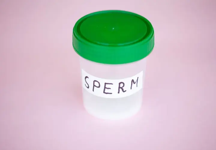 Contenitore con tappo verde, etichetta "SPERM". Potrebbe rappresentare un campione per analisi, legato a un'eiaculazione senza orgasmo.