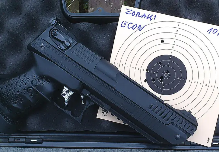 Pistolet Zoraki HP-01 Ultra obok tarczy strzeleckiej z widocznymi trafieniami na 10 metrów.