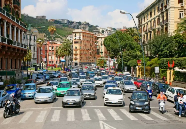 Busy street scene with cars and scooters, a typical day driving in Naples, Italy.