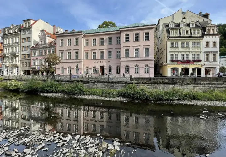 Nad rzeką w Karlowych Warach odbijają się w wodzie zabytkowe kamienice i budynek muzeum.