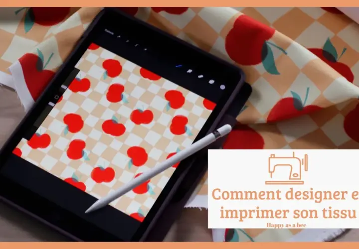 Un dessin sur tissu motif de pommes rouges sur fond à carreaux, visible sur une tablette et un échantillon de tissu.