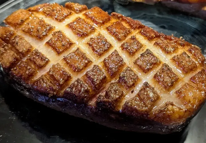 Magret de canard au four, la peau grillée en losanges, prête à être dégustée.