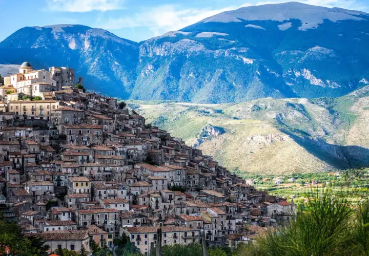 A picturesque village cascades down a mountainside, a perfect example of where to visit in Calabria for stunning views and historic charm.