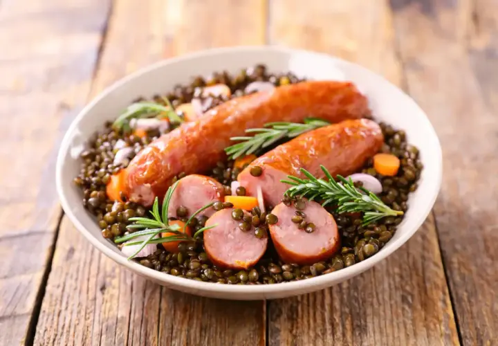 Saucisse lentille Cookeo : un plat réconfortant avec des saucisses savoureuses sur un lit de lentilles, carottes et romarin.