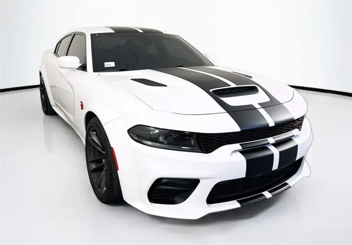 Biały Dodge Charger SRT z czarnymi pasami na masce i dachu, gotowy do jazdy.