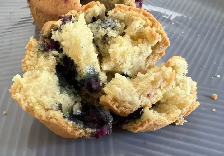 Muffin ai mirtilli appena sfornati nella friggitrice ad aria, con interno soffice e mirtilli succosi.