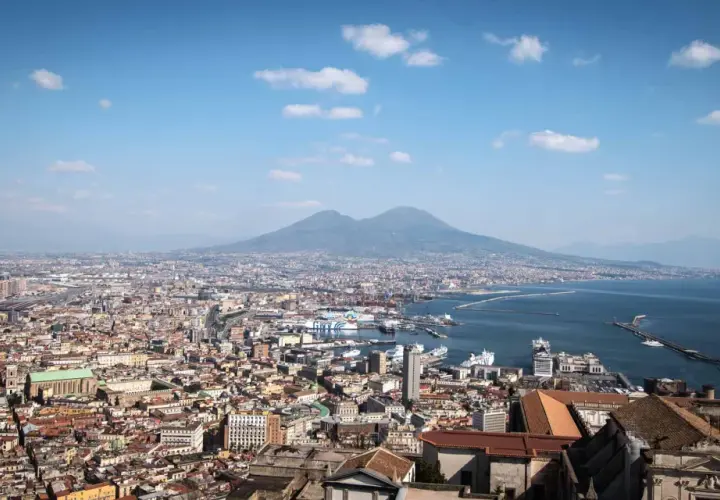 Panoramic view of Naples, Italy, with Mount Vesuvius in the background. Perfect for a Naples Italy itinerary, this vista captures the city's vibrant sprawl meeting the sea.