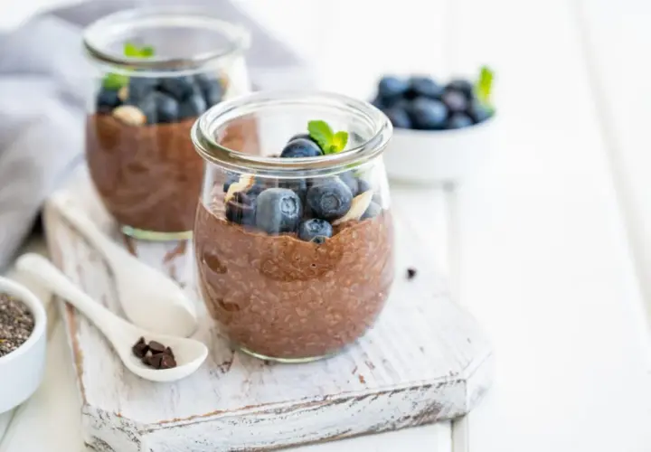 Czekoladowy pudding chia z jagodami i miętą w słoiku.