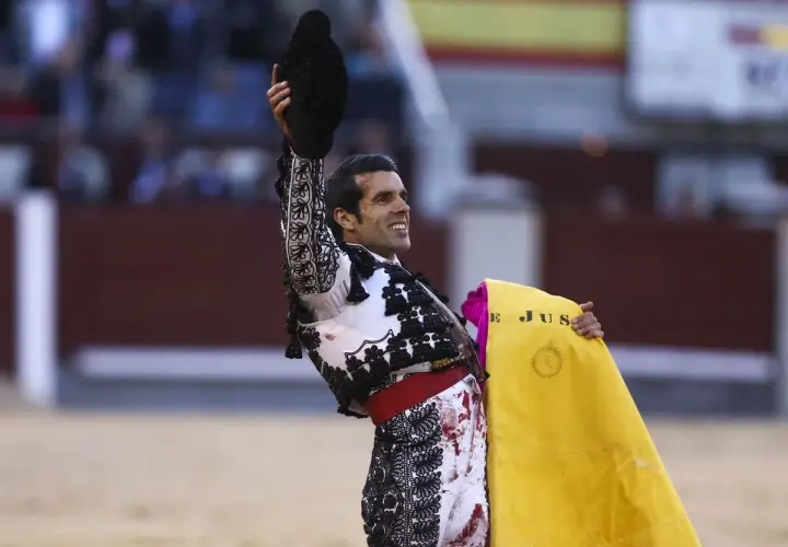 Un torero sonriente levanta su montera, con la muleta amarilla en la mano. Las caras de toreros son un reflejo de pasión y valentía.