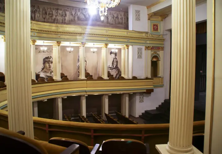 Wnętrze teatru im. H. Modrzejewskiej z portretami aktorek i malowidłem na ścianie.