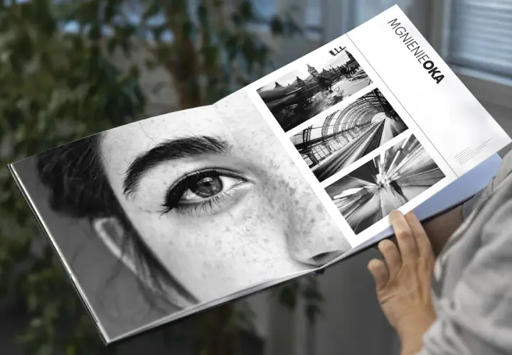 Osoba przegląda album "Mgnienie Oka", gdzie obok zbliżenia oka kobiety znajdują się czarno-białe fotografie miejskich krajobrazów i ruchu.