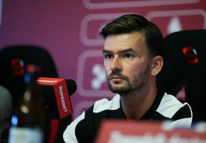Trener Górnika Zabrze, w czarno-białej koszulce, siedzi przy mikrofonie Superbet.