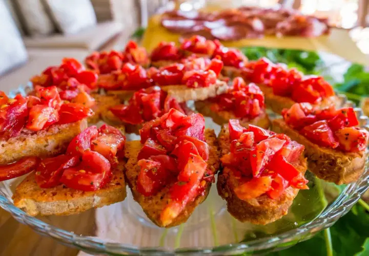 Pyszna bruschetta al pomodoro na chrupiących grzankach, udekorowana świeżymi pomidorami i ziołami. Idealna przekąska.