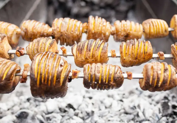 Pommes de terre coupées en accordéon, grillées à la broche sur des braises. Quelle pomme de terre barbecue !