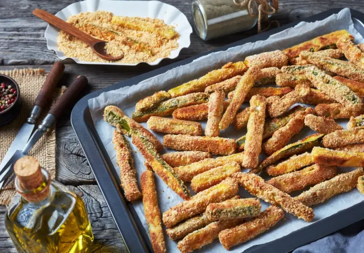 Bastoncini di zucchine al forno, dorati e croccanti, pronti per essere gustati.