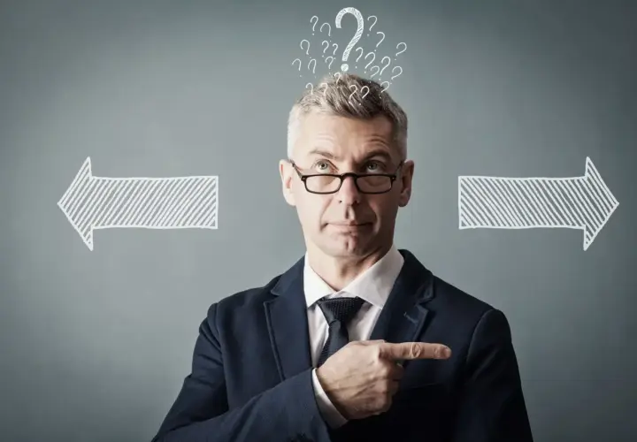 Un homme d'affaires réfléchit, entouré de points d'interrogation et de flèches. Il cherche la meilleure solution, peut-être avec un logiciel GED.