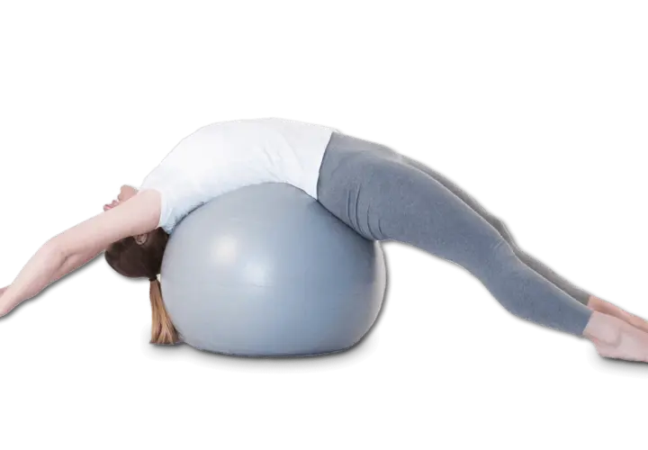 Une femme s'étire sur un ballon de gym, le dos cambré, dans une posture qui pourrait aider à corriger une cyphose.